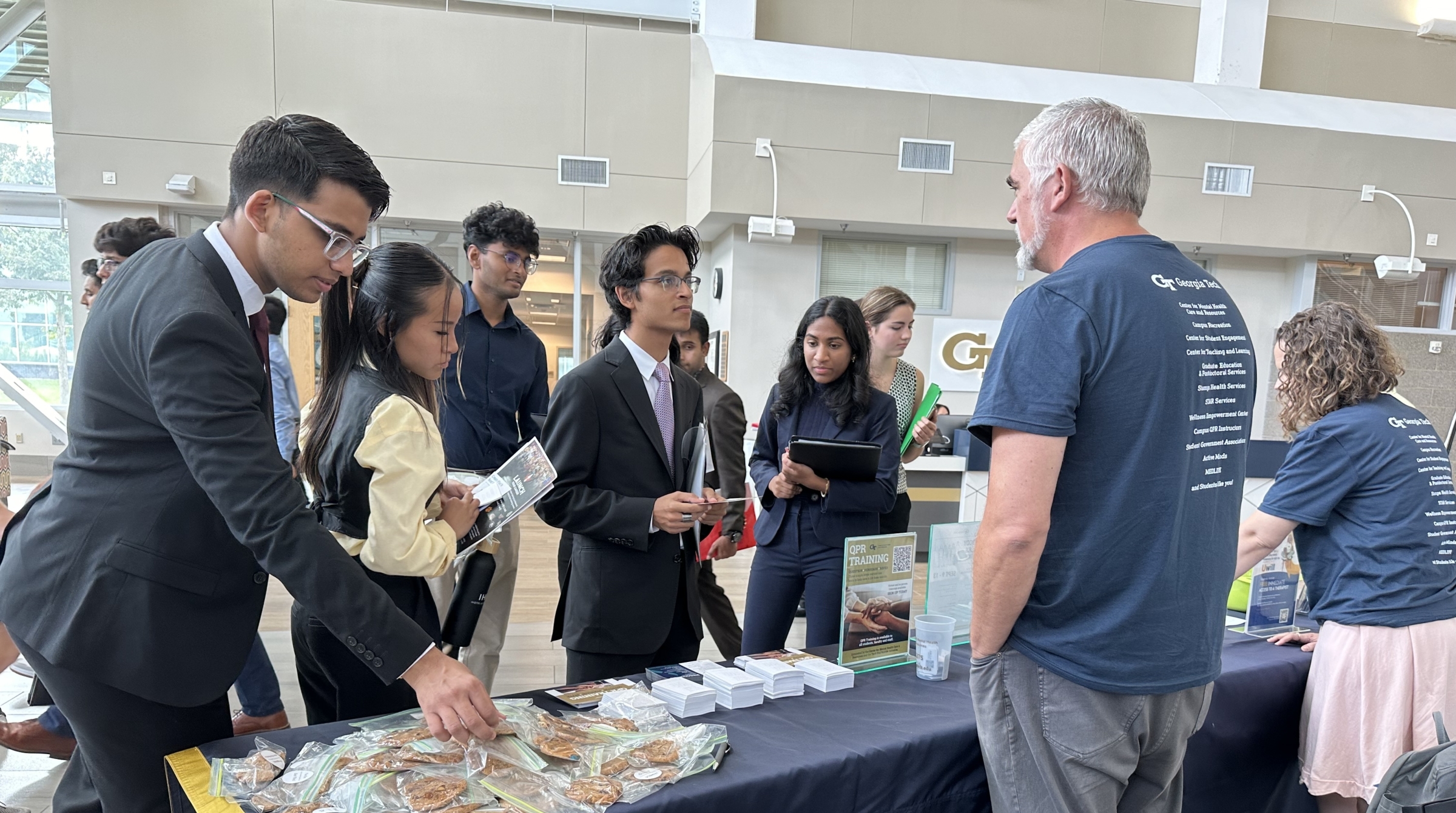 students talk to a counselor at a table